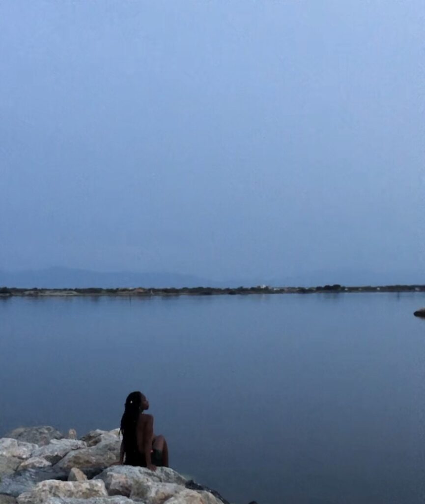 picture of aziza siankam in front of the lake where she medidate